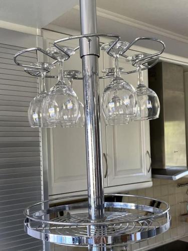 a glass holder with three wine glasses on a kitchen counter at Villa Oceanview Vicky in Pefkochori