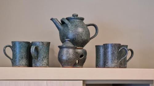four vases and cups sitting on a shelf at Toroni Pearl in Toroni