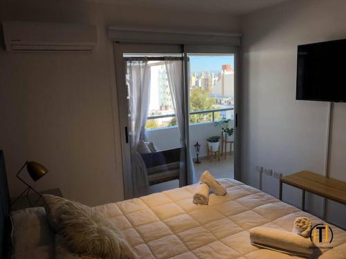 a bedroom with a large bed and a balcony at Campillo 988 in Córdoba