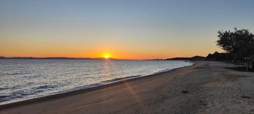 a sunset on a beach with the sun setting at Toroni Pearl in Toroni