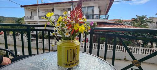 a yellow vase filled with flowers on a table at Toroni Pearl in Toroni