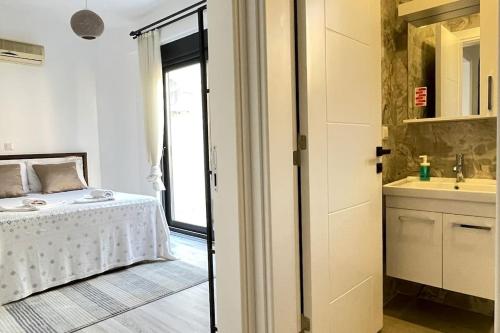 a bedroom with a bed and a bathroom with a sink at Ozy Apart Garden / Kaş-Çerçiler in Kas