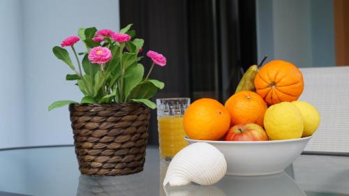a bowl of oranges and a bowl of flowers on a table at Toroni Pearl in Toroni