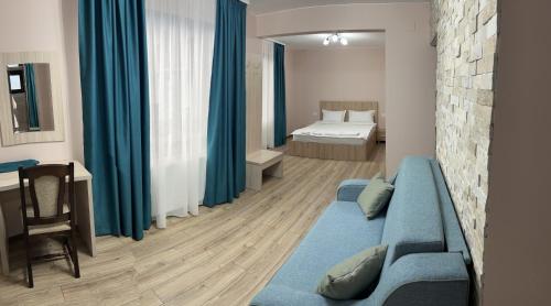 Casa TimEva Azuga في أَزوغا: غرفة معيشة مع أريكة زرقاء وغرفة نوم
