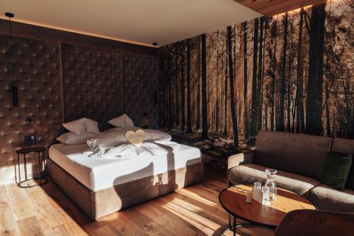 1 dormitorio con 1 cama y 1 sofá en Dilly - Das Nationalpark Resort, en Windischgarsten
