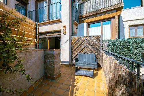 a patio with two chairs and a fence at Apartamentos Vino Tinto y Restaurante Tomate Rosa in Adahuesca