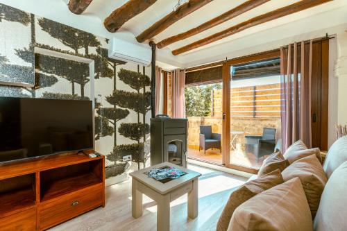 a living room with a couch and a television at Apartamentos Vino Tinto in Adahuesca