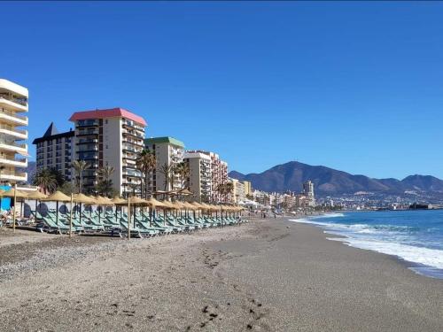 - une plage avec des chaises et des parasols et l'océan dans l'établissement BONITO APARTAMENTO, à Mijas