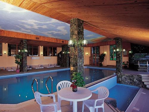 een patio met een tafel en stoelen naast een zwembad bij Diapolis Hotel in Akcakoca