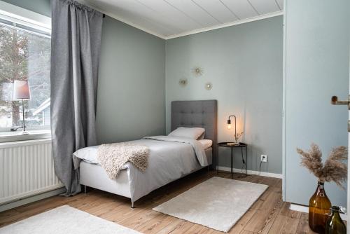 a bedroom with a white bed and a window at Munksund Apartments Villa in Piteå