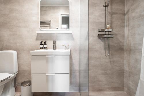 a bathroom with a white sink and a shower at Munksund Apartments Villa in Piteå