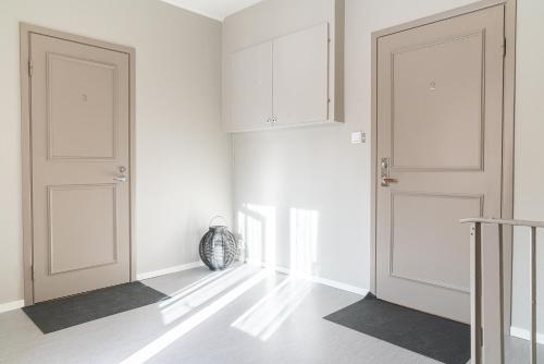 a white room with two doors and a hallway at Munksund Apartments Villa in Piteå