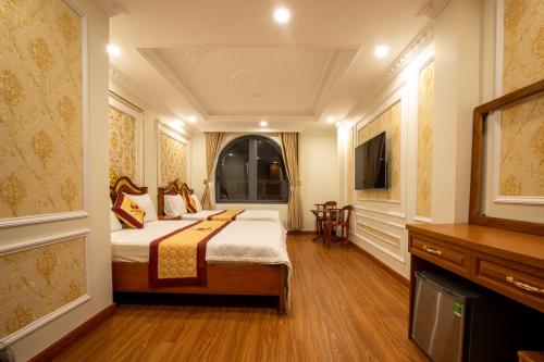 a hotel room with a bed and a television at TRÍ TÂM HOTEL - Khách sạn TRÍ TÂM Bến Lức in Bến Lức
