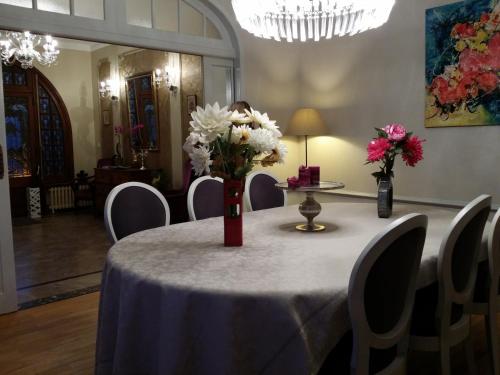 a table with a vase of flowers on top of it at Le Castel Guesthouse in Bayeux