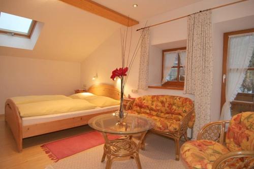 1 dormitorio con cama, mesa y sofá en Ferienwohnungen Neuhausenlehen en Ramsau