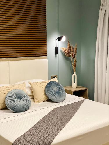 a bedroom with a bed with blue pillows on it at Leonidas House in Parga