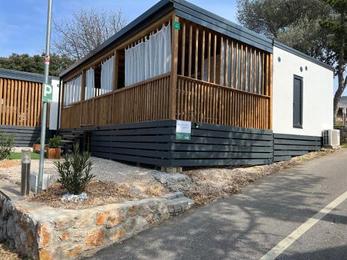 a building with a black and wooden facade on a street at Rosmarin&Olive Premium Mobile Homes in Selce