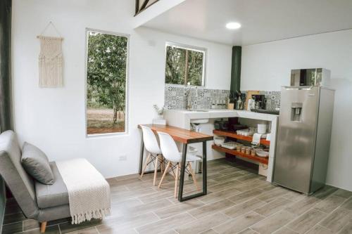 a kitchen with a table and a refrigerator at Casita Bohemia (Tiny House) in Fortuna