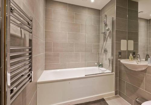 y baño con bañera y lavamanos. en 2-Bed Apartment only 15 mins from Central London, en Londres