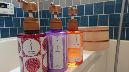 drei Flaschen auf einem Waschbecken in der Unterkunft Show和の宿つちや～豊臣の隠れ茶の間～ in Nagoya