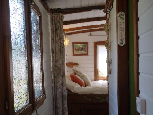 a small room with a small bed in a house at Roulotte Fleur des Champs in Sigalens