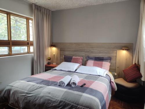 1 dormitorio con 1 cama con 2 toallas en Samayuna Wasi , entire apartment Cusco, en Cusco