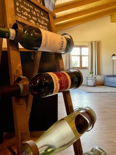 three bottles of wine on a wooden ladder at Ranch Enbrucà in Boves