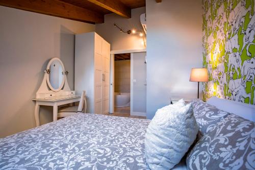 a bedroom with a bed and a mirror and a sink at Apartamentos Vino Tinto y Restaurante Tomate Rosa in Adahuesca