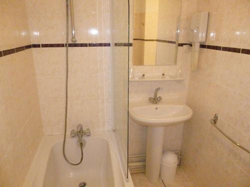 a bathroom with a sink and a toilet and a shower at Hotel California in Vichy