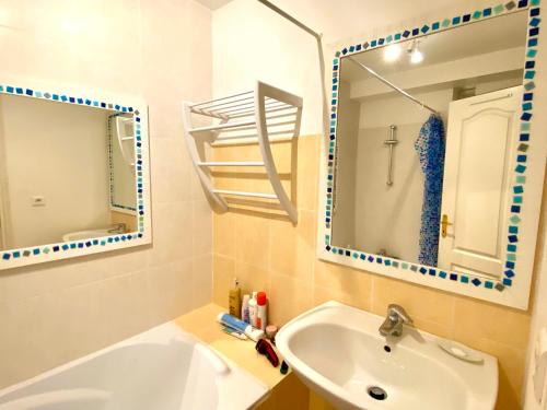 y baño con lavabo, bañera y espejo. en La Cardabelle, en Brousse-le-Château