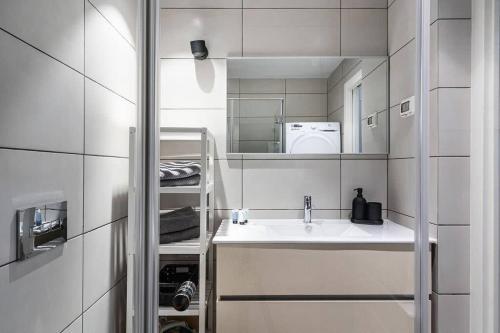 a white bathroom with a sink and a microwave at Gordon Beach by Five Stay in Tel Aviv