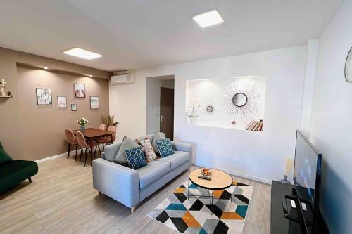 sala de estar con sofá y mesa en Accueillant T2 rénové clim centre ville terrasse en Brive-la-Gaillarde