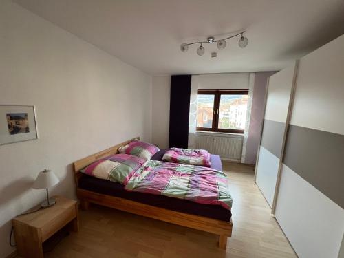 - une chambre avec un lit avec des draps roses et une fenêtre dans l'établissement Große Ferienwohnung, Apartment in Leimen WeHome Komfort, à Leimen