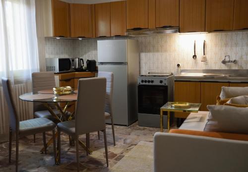 a kitchen with a table and a kitchen with a refrigerator at Appartamento Diana Cervia in Cervia