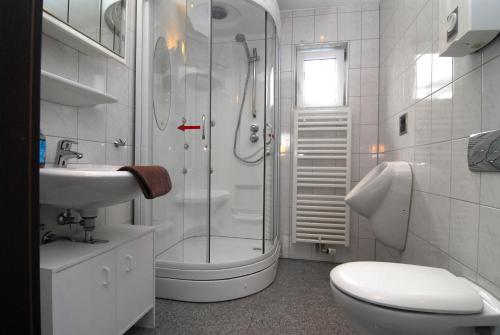 a bathroom with a shower and a toilet and a sink at Ferienwohnung + Monteurwohnungen Krings in Eschweiler