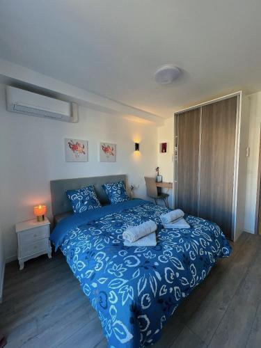 - une chambre avec un lit bleu et une couette bleue dans l'établissement Accueillant T2 rénové clim centre ville terrasse, à Brive-la-Gaillarde