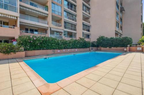 une piscine vide en face d'un bâtiment dans l'établissement Mer et Plage YourHostHelper 2 étoiles, à Cannes