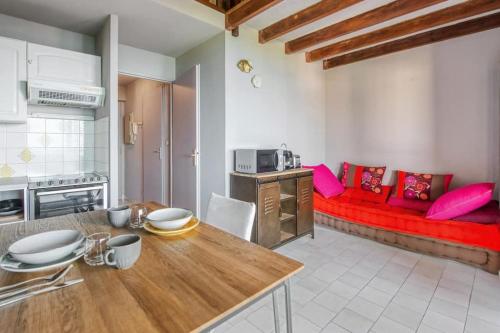 Il comprend une cuisine et un salon avec un canapé rouge. dans l'établissement Mer et Plage YourHostHelper 2 étoiles, à Cannes