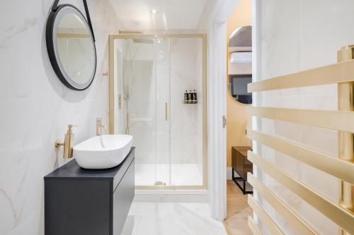 La salle de bains blanche est pourvue d'un lavabo et d'un miroir. dans l'établissement Luxury Apartment in the heart of Central London, à Londres