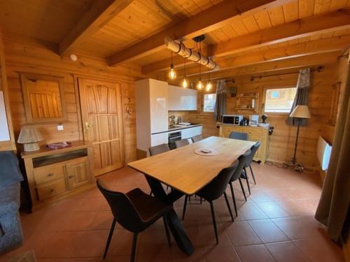 une cuisine et une salle à manger avec une table et des chaises en bois dans l'établissement Chalet spacieux avec piscine, parking et animaux admis - FR-1-504-624, à Saint-Étienne-en-Dévoluy