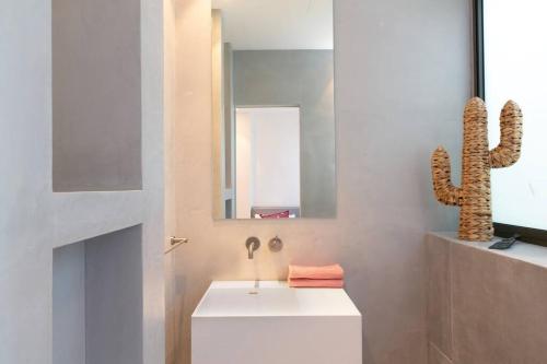 baño con lavabo blanco y cactus en Green Harmony by Five Stay, en Tel Aviv