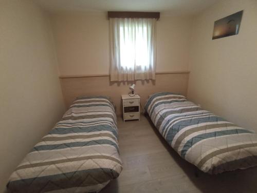 2 łóżka w małym pokoju z oknem w obiekcie vololiberoapartments w mieście Borso del Grappa
