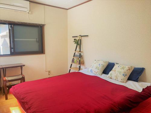 a bedroom with a red bed with a red blanket at 湘南の丘のヴィラーSweet Room in Fujisawa