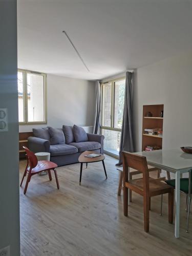 un salon avec un canapé bleu et une table dans l'établissement Villard de Lans, coeur de village.Bel appartement, à Villard-de-Lans