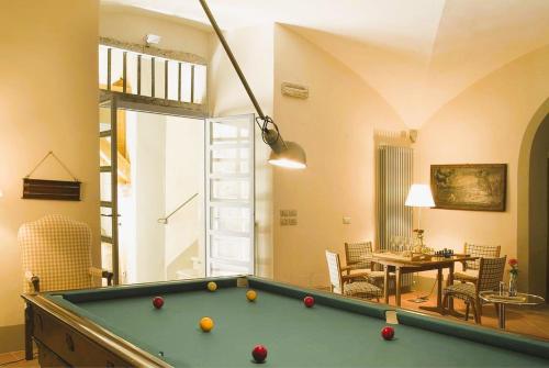 Pian di ScòにあるExclusive Borgo in Tuscanyのビリヤード台とダイニングルームが備わる客室です。