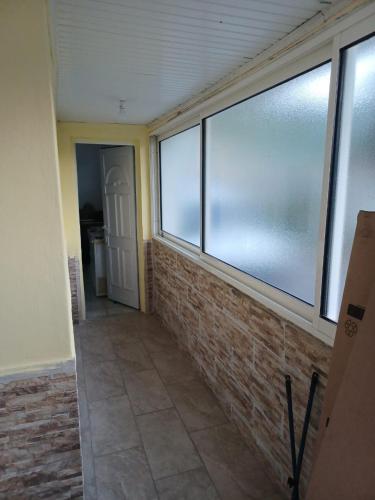 una camera con una grande finestra e un muro di mattoni di Maison tartanaise a La Trinité
