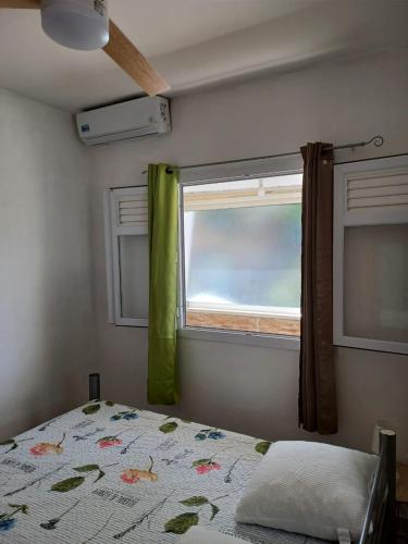 a bedroom with a bed and a window at Maison tartanaise in La Trinité