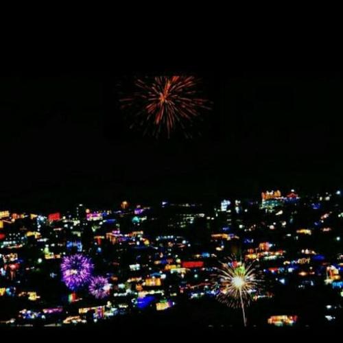 a fireworks display over a city at night at MangalMurti Himalyan Hotel in Almora