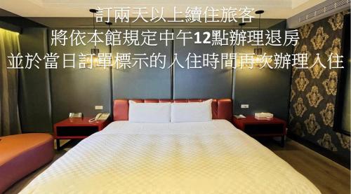 a bedroom with a large bed and some writing on the wall at Janeeyre Motel in Taichung