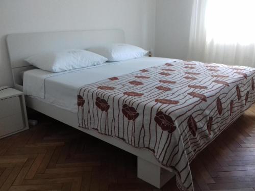 a bed in a bedroom with a blanket on it at Apartment Dragan in Pula